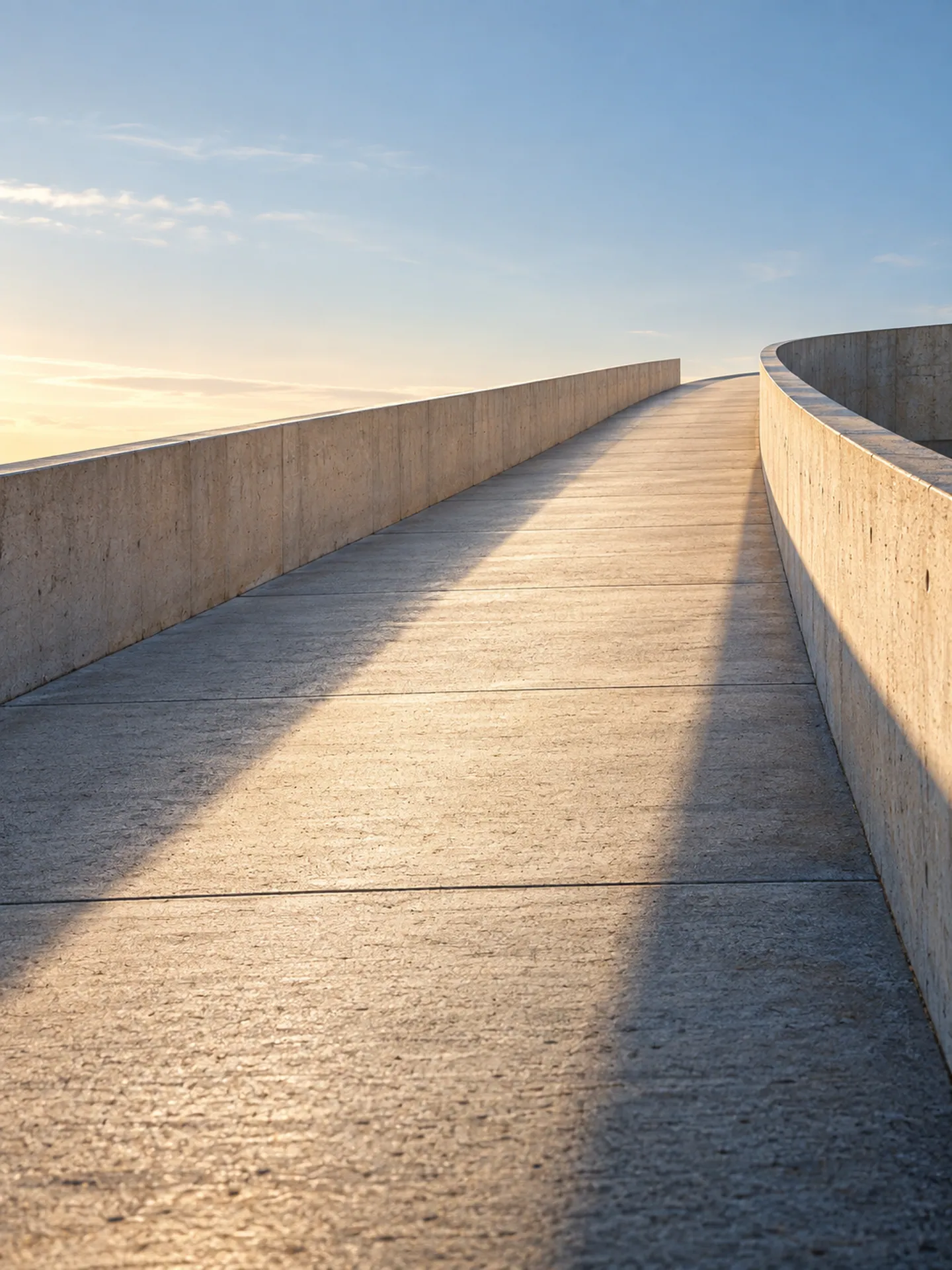 Rampa de concreto claro subindo em direção ao céu ao amanhecer